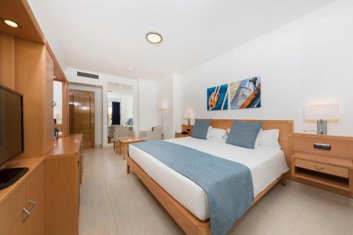 a hotel room with a bed and a television at Ukino Palmeiras Village - 24h All Inclusive in Armação de Pêra
