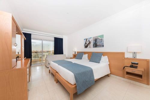a hotel room with a bed and a television at Ukino Palmeiras Village - 24h All Inclusive in Armação de Pêra