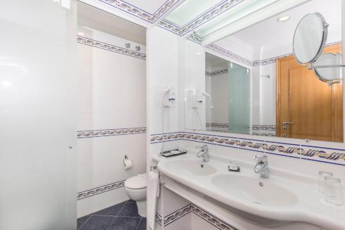 un baño con lavabo e inodoro en Ukino Palmeiras Village - 24h All Inclusive, en Armação de Pêra