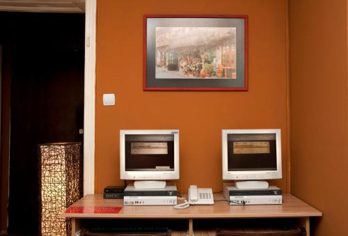 dos monitores de ordenador sentados en un escritorio con un teléfono en Hostel Mostel Hub Rooms and Apartments en Sofía