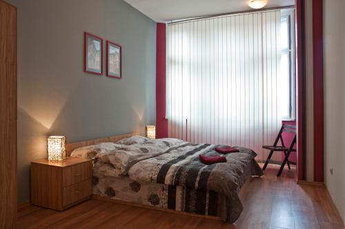 a bedroom with a bed and a table and two lamps at Hostel Mostel Hub Rooms and Apartments in Sofia