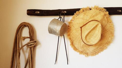 a straw hat hanging on a wall with ropes at Masseria Uccio in Tricase