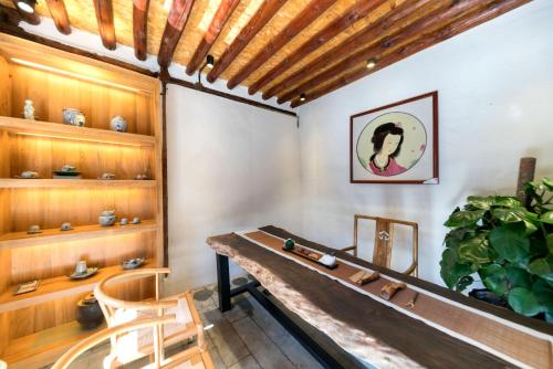 a dining room with a table and a plant at Dali Old Courtyard Boutique Inn in Dali