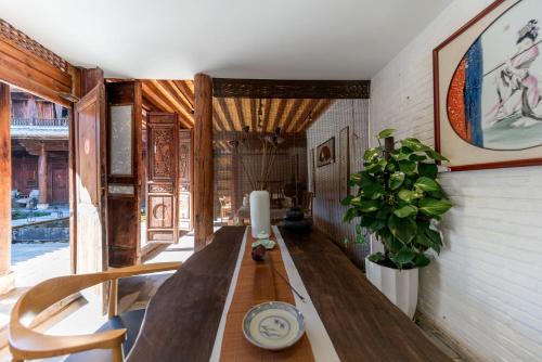 a dining room with a long table and a plant at Dali Old Courtyard Boutique Inn in Dali