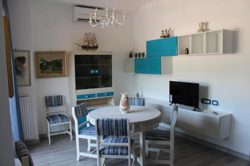 a dining room with a table and chairs and a tv at Seaview Apartment Monterosso, Cinque Terre in Monterosso al Mare