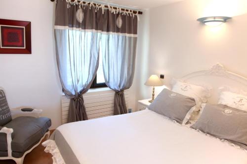 オルムトにあるVilla le Mas de Pierreのベッドルーム1室(ベッド1台、青いカーテン付きの窓付)