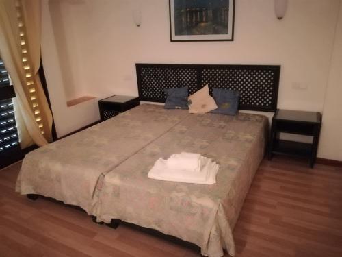 アルブフェイラにあるCasa da Quinta da Bela Vista T2のベッドルーム1室(大型ベッド1台、タオル付)
