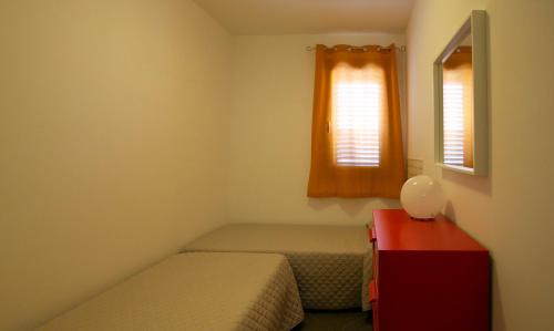 a small bedroom with two beds and a window at Boa Vista San Vito - Area Fitness, Barbecue Area, Tennis Court in San Vito lo Capo