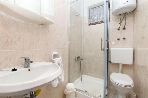 a bathroom with a sink and a toilet and a shower at Sobe Lea in Sukošan