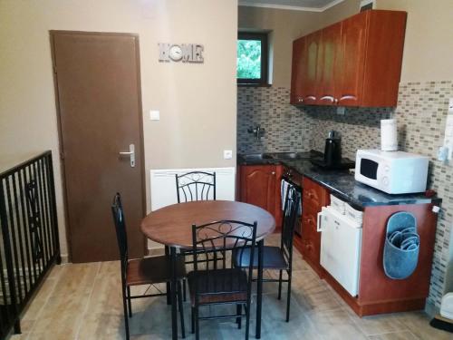 a kitchen with a table and chairs and a microwave at Bella Vendégház in Etyek