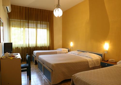 pokój hotelowy z dwoma łóżkami i telewizorem w obiekcie Hotel Sole w mieście Nocera Inferiore
