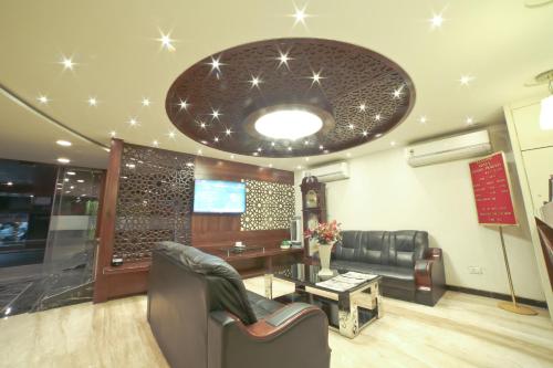 a waiting room with a couch and a table at Hotel Grand Pragati in Surat