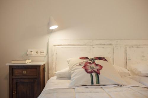 a bedroom with a bed with a flower on the pillow at Casa das Landras in Chantada