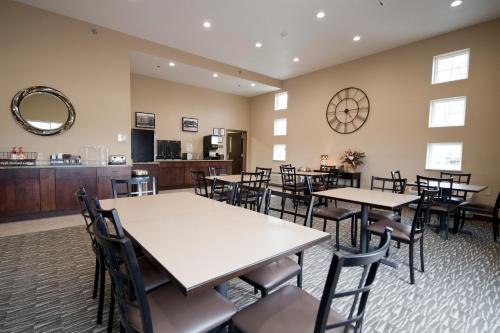 um restaurante com mesas e cadeiras num quarto em Cornerstone Inn & Suites Oelwein em Oelwein