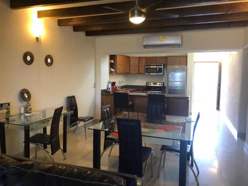 a kitchen and dining room with a glass table and chairs at Marina Nopolo 413 in Loreto