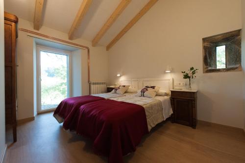 a bedroom with a large bed and a window at Casa das Landras in Chantada