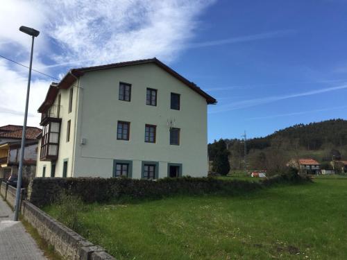 una casa blanca en un campo con un patio verde en La casa de los abuelos, en Zurita