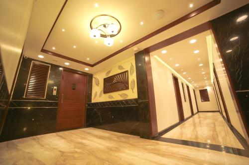 a room with a hallway with a door and a chandelier at Hotel Grand Pragati in Surat