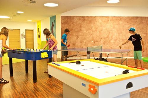 a group of children playing table tennis in a room at Hotel Grüner Baum in Bressanone