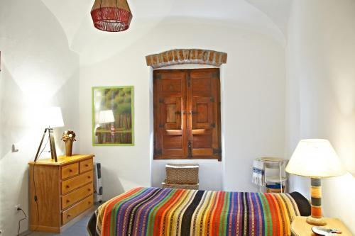 a bedroom with a bed and a dresser and a wooden door at Pinheiro de Monsaraz- Casa De Santa Maria T3 com piscina in Reguengos de Monsaraz