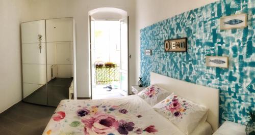um quarto com uma cama com flores na parede em Tino'S House em La Spezia