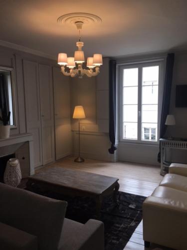 a living room with a couch and a chandelier at SAINT MALO Appartement in Saint Malo