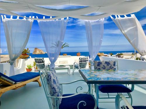a balcony with a table and chairs and the ocean at La Ginestra in Panarea