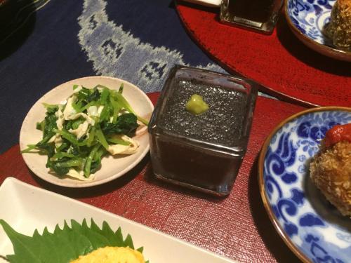 a table with plates of food and a plate of salad at Gallery Nozawa Inn in Kyoto