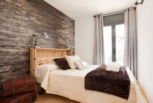 sypialnia z dwoma łóżkami i ceglaną ścianą w obiekcie Apartment Beach Front Canet w mieście Canet de Mar