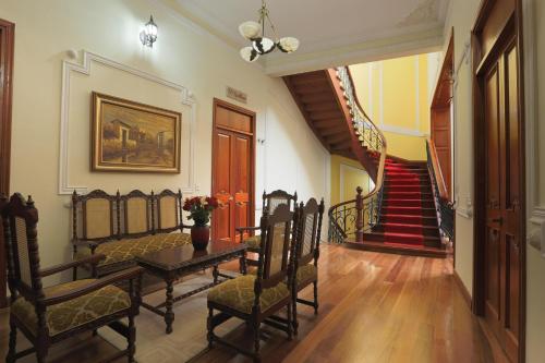 a dining room with a table and chairs and a staircase at Hotel Santa Lucia Boutique Spa in Bogotá