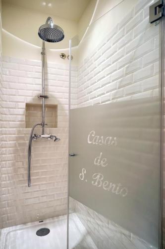 a shower in a bathroom with white brick walls at Casas de São Bento in Lisbon