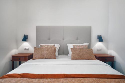 a bedroom with a large white bed with two tables at Casas de São Bento in Lisbon