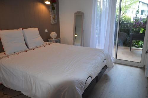 バイヨンヌにあるresidence saint bernardのベッドルーム(大きな白いベッド1台、バルコニー付)