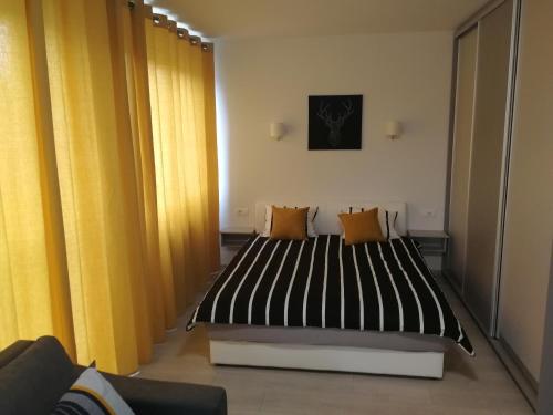 um quarto com uma cama com cortinas pretas e amarelas em Apartment Oasis BANOVO BRDO-ADA CIGANLIJA em Belgrado