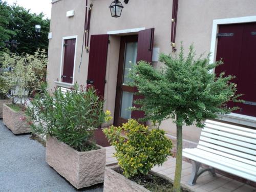 a bench sitting in front of a building with plants at Albergo La Bersagliera in Noventa di Piave