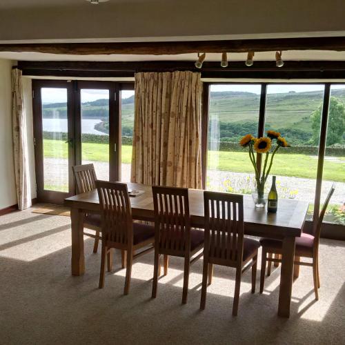 a dining room with a table and chairs and a window at Pott Hall in Masham