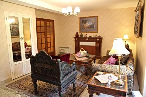 ein Wohnzimmer mit einem Sofa und einem Tisch in der Unterkunft The Storyteller Apartment at Chateau Le Mur in Carentoir