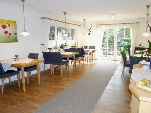 a dining room with wooden tables and blue chairs at Pension Am Wiesengrund in Detern