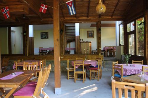 un ristorante con tavoli e sedie in legno e bandiere di Motel Lepo Mesto a Strmosten