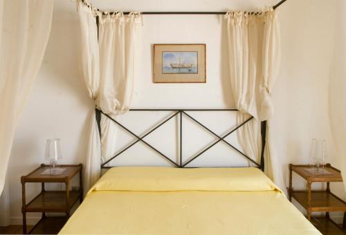 a bedroom with a yellow bed with two night stands at Casa la Mimosa in Leuca