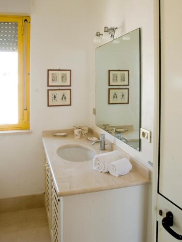 a bathroom with a sink and a large mirror at Casa la Mimosa in Leuca