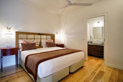 a bedroom with a large bed and a bathroom at Casas de São Bento in Lisbon