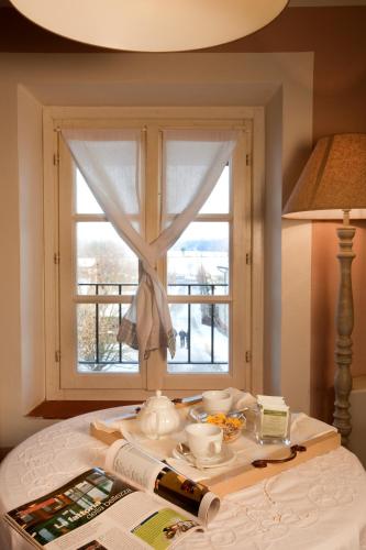 a table with a window in a room with a book at Agriturismo Cascina Caremma in Besate