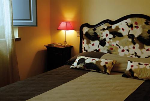 a bedroom with a bed with a floral headboard and a lamp at Residenza Ca De Frati in Arezzo
