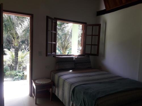 een slaapkamer met een bed en een raam bij Siqueira, aluguéis para temporadas in Paraty