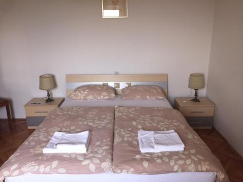 a bedroom with two beds and two night stands at Apartments and Rooms Ješelnik in Portorož