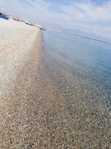 a beach with a large amount of rocks and water at B&B Altamarea in Marina di Schiavonea