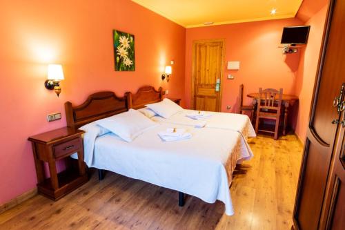 a bedroom with a large bed with white sheets at Hotel Peña Pandos in Felechosa