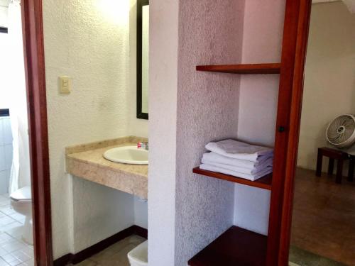 ein Bad mit einem Waschbecken und einem Spiegel in der Unterkunft Hotel Roma in Oaxaca de Juárez