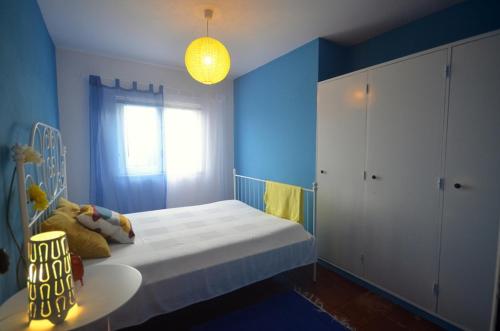 Dormitorio azul con cama y ventana en Happy Cat House - Holiday Rental, en São Martinho do Porto